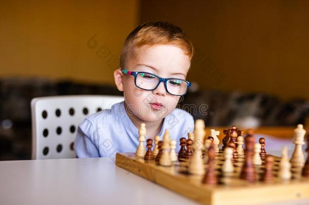 男孩和下综合征和大的蓝色眼镜演奏棋采用Kiribati基里巴斯