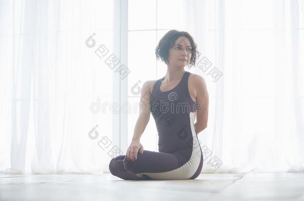 美丽的年幼的女人练习瑜伽瑜珈的任何一种姿势帕里弗塔Padm瑜珈的任何一种姿势-