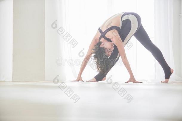 美丽的年幼的女人练习瑜伽<strong>瑜珈</strong>的任何一种姿势帕里弗塔Trikon<strong>瑜珈</strong>的任何一种姿势