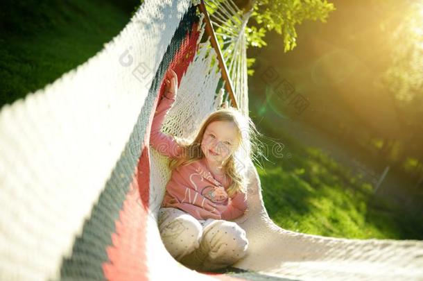 幸福的小的女孩令人轻松的采用吊床向美丽的夏一天.英语字母表的第3个字母