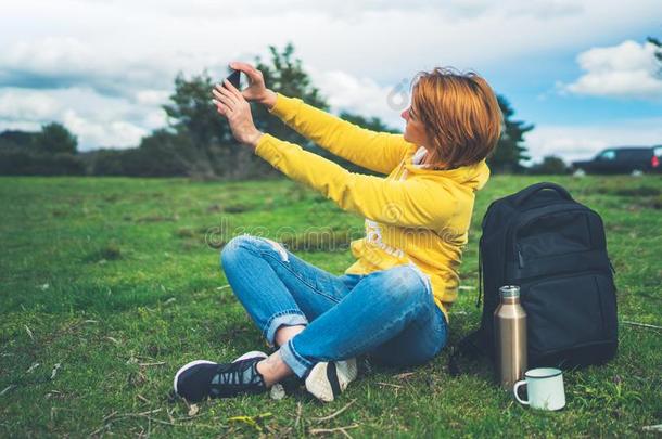 旅行者女孩向背景绿色的草迷人的照片自拍照向=moment