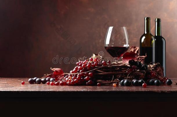 红色的葡萄酒和新鲜的葡萄和干燥的在上面藤树叶.