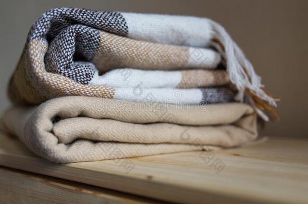 家纺织品.垛关于米黄色羊毛毛毯向一木制的架子.