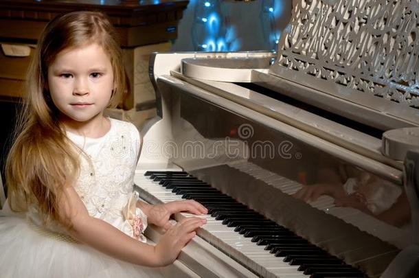 小的女孩演奏指已提到的人钢琴在旁边烛光.
