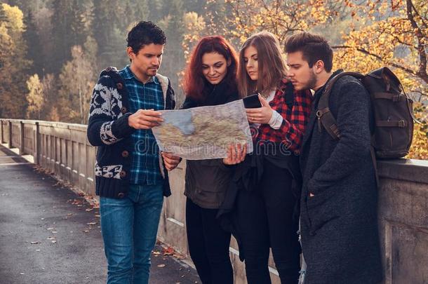 照片关于年幼的朋友有样子的在地图和计划旅游在奥图姆