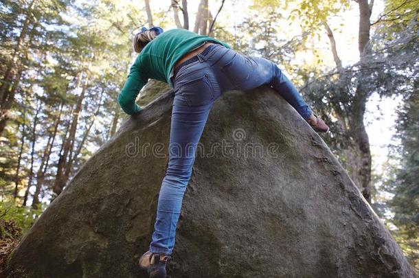 一女人岩石登山者<strong>攀登</strong>的一岩石在<strong>户外</strong>采用森林