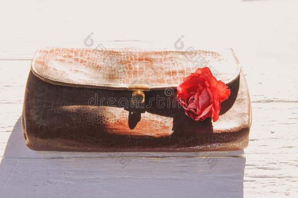 老的皮酿酒的小手提袋袋和玫瑰