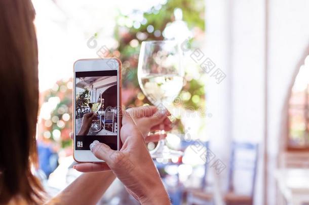 女人迷人的照片关于白色的葡萄酒向她smartph向e采用<strong>饭店</strong>