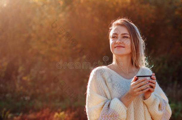 美丽的赞赏的女人喝饮料热的茶水从热水瓶杯子