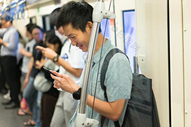 幸福的男人是（be的三单形式旅行支票使用智能手机在地铁为旅行