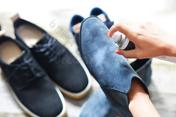 鞋子关心观念和女人手喷雾皮鞋