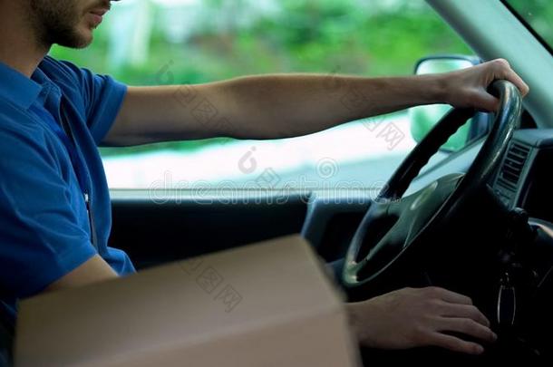 邮递员操纵汽车,汽车dboard盒起立在近处他,包裹前妻或前夫