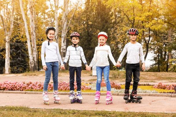 幸福的孩子们使人疲乏的滚筒溜冰鞋采用公园