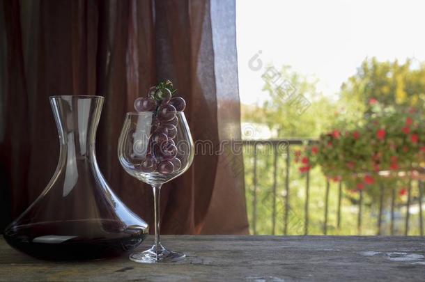 意大利人红色的葡萄酒里面的指已提到的人玻璃水瓶和高脚酒杯和装饰