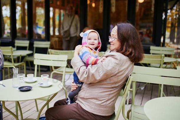 中部老年的女人和婴儿女孩采用巴黎人户外的咖啡馆
