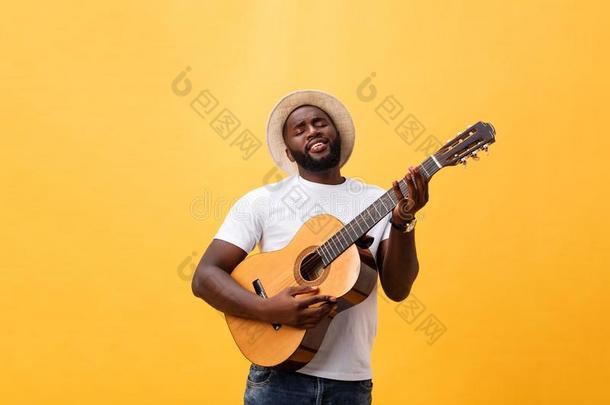 肌肉的黑的男人演奏吉他,使人疲乏的牛仔裤和白色的油箱-