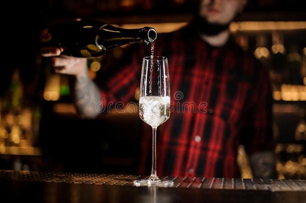 酒吧间男招待员传布香槟酒进入中一eleg一t玻璃