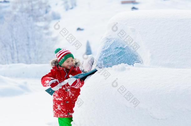 小孩疾驰的从落下汽车.小孩和冬雪刷子