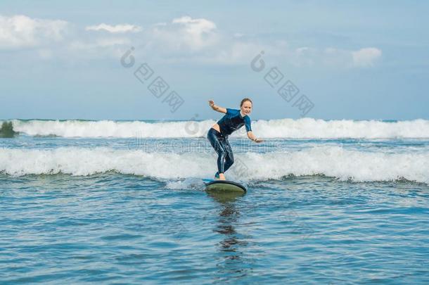 快乐的年幼的女人<strong>新手</strong>冲浪运动员和蓝色海浪有乐趣向subjectmatterarea主题区