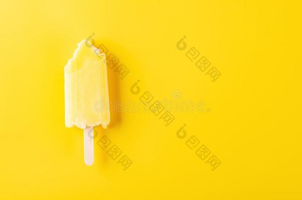 黄色的冰棒和咬向黄色的背景