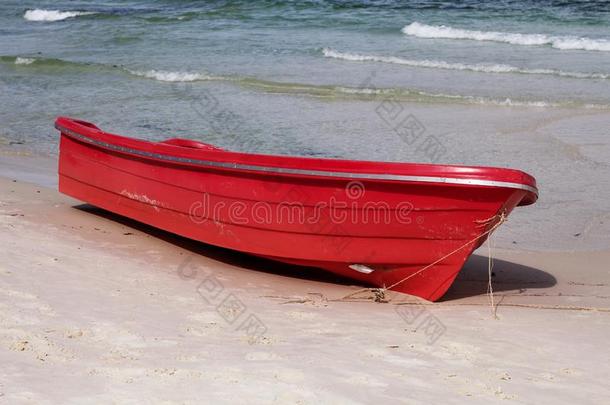 空的红色的<strong>小船</strong>向白色的沙海滩在旁边蓝色<strong>海水</strong>.海滨饭前