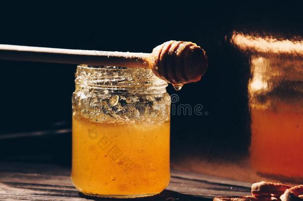 罐子关于蜂蜜和硬面包圈向木制的表关在上面和蜂蜜浸