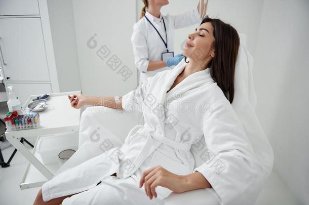 年幼的女士静止的在期间医生调节进入静脉的滴下