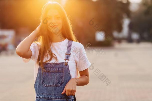 有魅力的漂亮的女孩和公文包走向大街在早晨