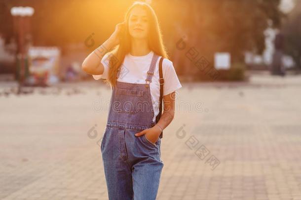 有魅力的漂亮的女孩和公文包走向大街在早晨