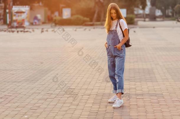 有魅力的漂亮的女孩和公文包走向大街在早晨