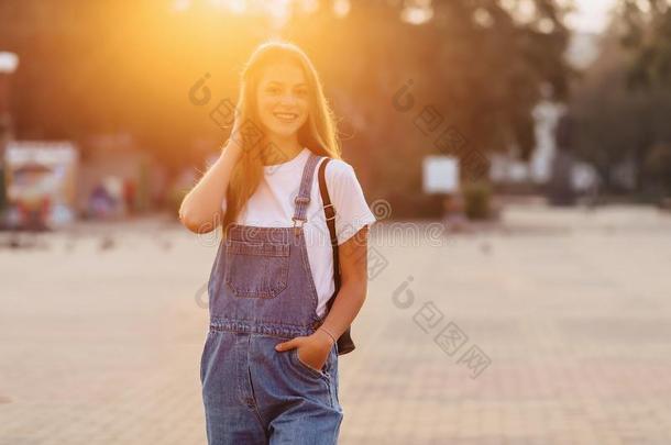 有魅力的漂亮的女孩和公文包走向大街在早晨