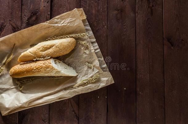 法国的法国长面包和芝麻种子向一p一perb一g躺向一木制的