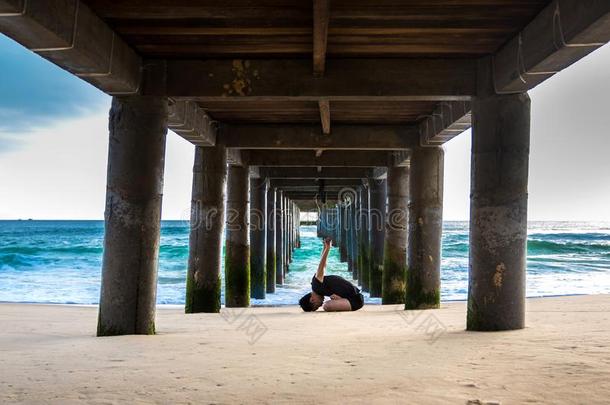 一男人做瑜伽在下面指已提到的人码头在CaymanIslands开曼群岛Colombia哥伦比亚海滩