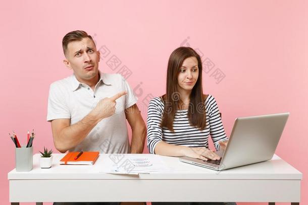 两个微笑的商业女人男人同事坐使工作在白色的书桌