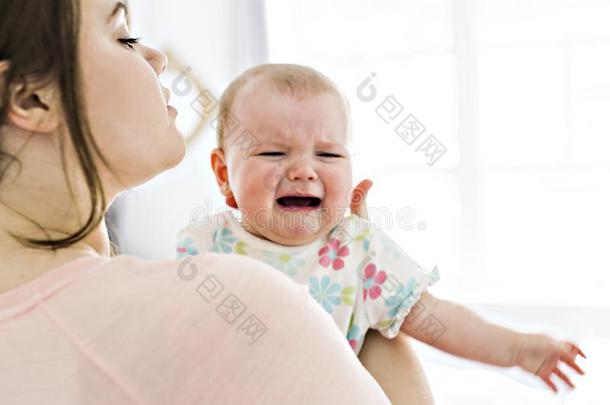 母亲和婴儿热烈地拥抱和可安慰的在卧室