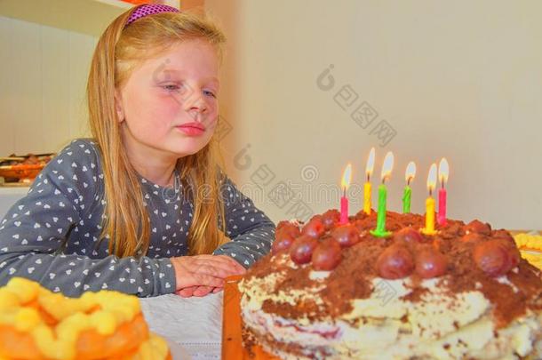 小的女孩有样子的向她生日蛋糕.小的女孩庆祝