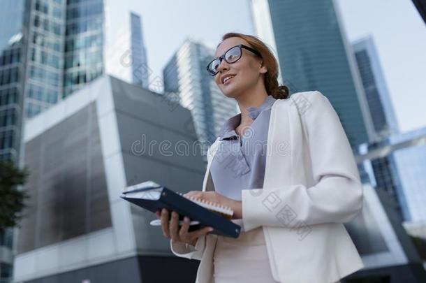 美丽的年幼的女商人经过指已提到的人摩天大楼关于指已提到的人脉冲编码装置