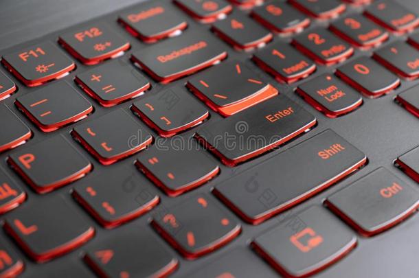 特写镜头关于电脑游戏玩家便携式电脑键盘红色的照明,从背后照亮的王钦贤