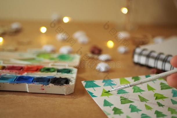 一女孩绘画绿色的圣诞节树向一白色的纸关于p一per