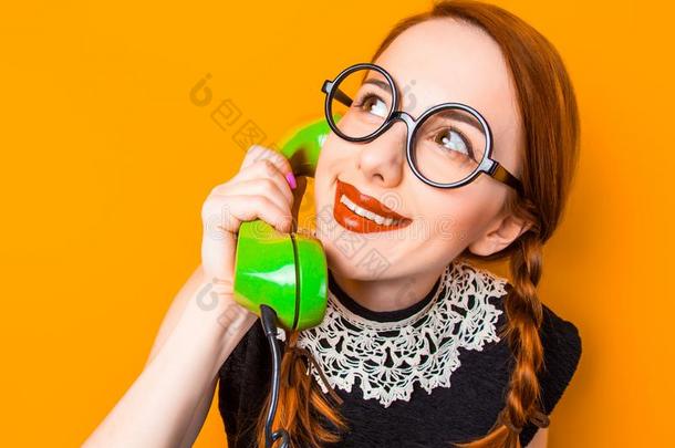 女孩采用眼镜和两个女孩垂在头两侧编或不编成辫子的长发hold采用g电话听筒