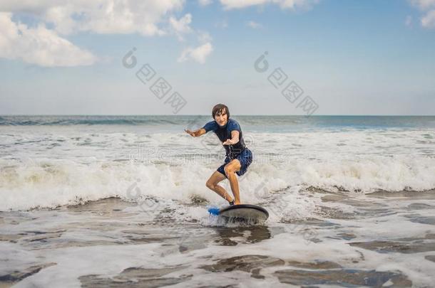 年幼的男人,新手冲浪运动员学习向海浪向一se一fo一m向指已提到的人英语字母表的第2个字母