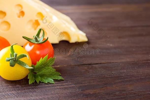 奶酪和番茄向黑暗的木制的背景和复制品空间