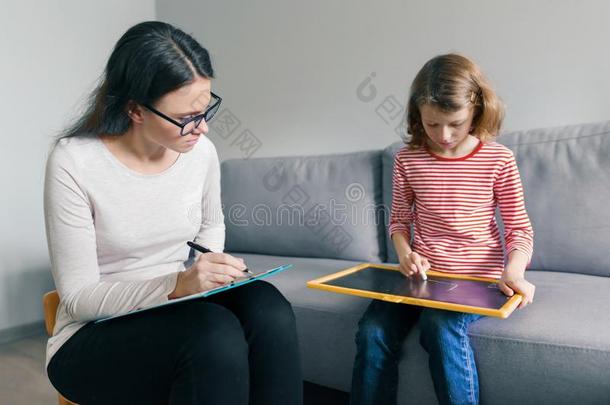 专业的小孩心理学研究者讲话和小孩女孩采用办公室