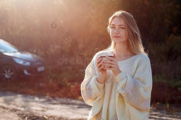 美丽的赞赏的女人喝饮料热的茶水从热水瓶杯子