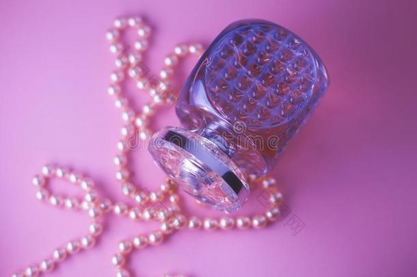 香水瓶子和<strong>珍珠项链</strong>向粉红色的背景