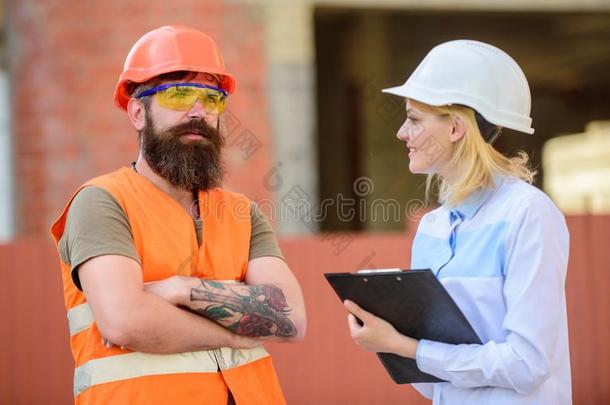 女人检查员和有胡须的野蛮的建设者讨论建筑物