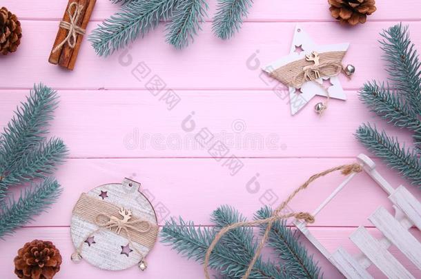 冷杉树树枝和圣诞节玩具向粉红色的背景