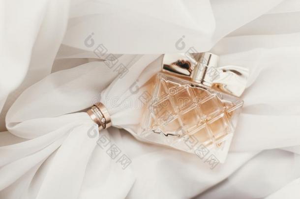 现代的婚礼金色的戒指和时髦的香水瓶子向软的英语字母表的第6个字母