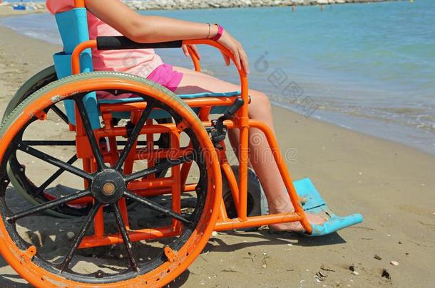 小的女孩向指已提到的人轮椅和特殊的金属轮子