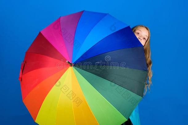 女孩欢乐的隐藏在的后面雨伞.富有色彩的雨伞附件.